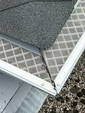 Homeowner-installed gutter cover at an inside roof corner, removed and replaced
